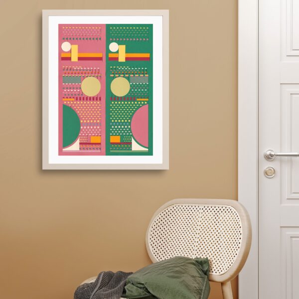 Paret de color camel amb una peça de paper emmarcada amb dos colors predominants: verd i rosa. Al costat hi ha una porta i just a sota de la peça emmarcada, una cadira amb una manta damunt